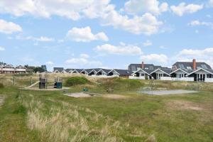 Un parque con una zona de juegos infantiles frente a las casas. en 0291-Romo-Vestergade-3-Ap-65, en Havneby