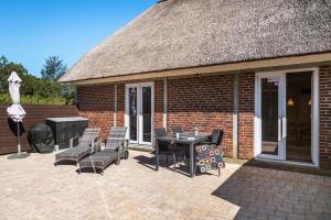 un patio con sedie e un tavolo e un edificio di BV230-Blavand-Vesterhavsparken-35 a Blåvand