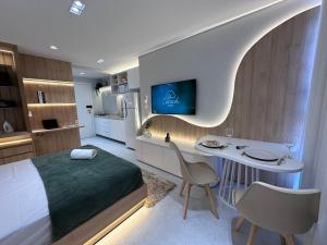 a bedroom with a bed and a desk and a tv at City House Exclusive - By Caracol Urbano in Barreiras