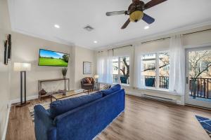 a living room with a blue couch and a ceiling fan at Loft Apt with Balcony in the Heart of Kennett Square in Kennett Square