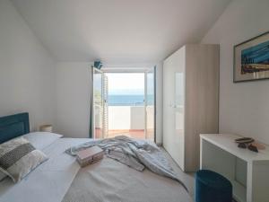 a bedroom with a bed with a view of the ocean at Apartments Maestral in Trpanj