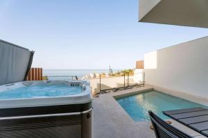 a hot tub on a balcony with the ocean in the background at House with Private Spa and Pool, with access to Sauna and Gym in Torrox Costa +11 photos