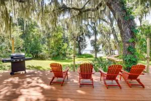a group of chairs sitting on a deck with a grill at Little Lake George Hideaway with Furnished Boathouse in Welaka