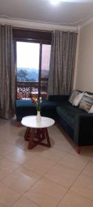 a living room with a couch and a table at Hommy Accommodation in Kampala