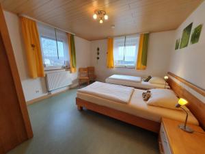a bedroom with two beds and two windows at Rennerhof-Siebeneichen Fewo Laubfrosch in Sulzbach-Rosenberg