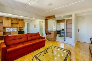 a living room with a couch and a glass table at Apto 1 dorm., amplo e todo equipado, perto do Parcão in Porto Alegre