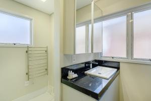 a bathroom with a sink and a mirror at Apto 1 dorm., amplo e todo equipado, perto do Parcão in Porto Alegre