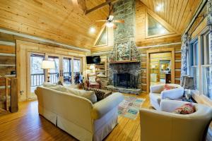 una sala de estar con sofás y una chimenea de piedra. en Scenic Getaway - Hot Tub & Mountain Views, en Mentone