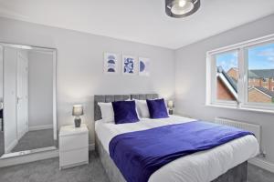 una camera da letto con un letto grande e una finestra di Spacious 3-Bed House with Parking and Garden ad Aylesbury