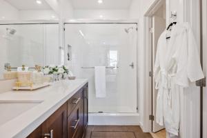 a white bathroom with a shower and a sink at Luxury Resort Pool Spa Arcade Movie Gym in Mission Viejo +42 photos