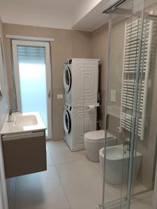 a bathroom with a toilet sink and a washing machine at Petra Nova in Sarno