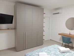 a bedroom with a large white cabinet and a bed at Petra Nova in Sarno