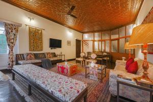 a living room with couches and a tv at SaffronStays Awakening -Family Suite in Srinagar