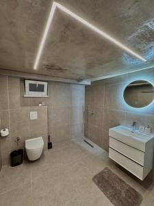 a bathroom with a white toilet and a sink at Nest Apartments in Tirana