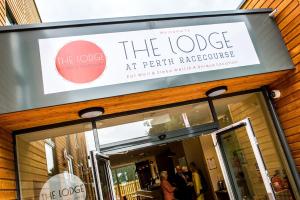 a sign for the lodge at perth restaurant at The Lodge At Perth Racecourse in Perth