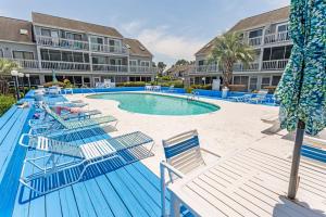 a swimming pool with blue chairs and a beach at NEW! Large 1BR at The Golf Colony at Baytree, Pool in Stephens Crossroads