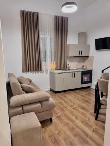 a living room with a couch and a kitchen at Nest Apartments in Tirana +26 photos