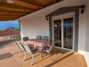 a table and chairs on a balcony with a table and a window at RelaxVila Ksamil in Ksamil
