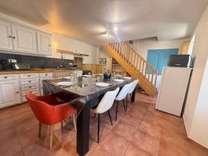a kitchen with a table with chairs and a refrigerator at L' Altitude Billard Proche Stations Cols in Saint-Michel-de-Maurienne