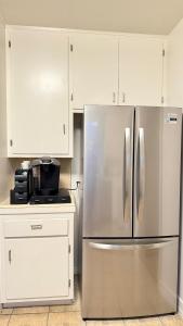 einen Kühlschrank aus Edelstahl in einer Küche mit weißen Schränken in der Unterkunft Upgraded 2B1B near to Old Town Pasadena Caltech in Pasadena