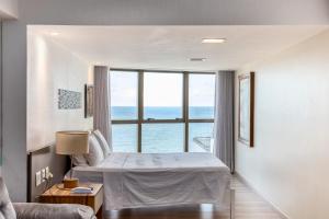 Un dormitorio con una cama y una ventana grande. en BEIRA MAR- FLAT EXECUTIVE, en Recife