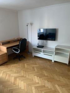 Habitación con escritorio, TV y silla. en Your home 22, en Košice