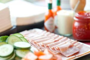 a plate with meat and cucumbers on a table at Holiday Inn Express Zürich Airport by IHG in Rümlang
