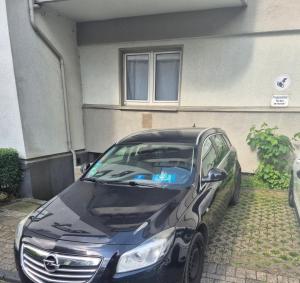 a black car parked in front of a house at Cosy Appartement in elberfeld in Wuppertal