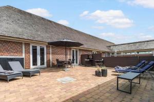 un patio esterno con sedie e un ombrellone di BV255-Blavand-Vesterhavsparken-39 a Blåvand