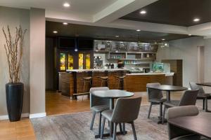 a restaurant with tables and chairs and a bar at Courtyard St. Louis Airport/Earth City in Bridgeton