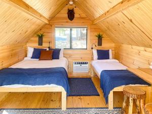 una camera con due letti in una baita di legno di Blue Buffalo Resort a Island Park