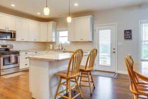 a kitchen with white cabinets and a island with bar stools at 14 Mi to Ark Encounter Rural Corinth Escape! in Corinth +23 photos