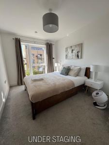 a bedroom with a large bed and a window at Grover Court - Modern Stay with Free Gated Parking & WiFi in Kings Langley +1 photo