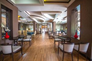 a dining room with tables and chairs in a restaurant at Grand Hotel in Elbasan