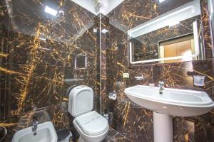 a bathroom with a sink and a toilet and a mirror at Grand Hotel in Elbasan +45 photos