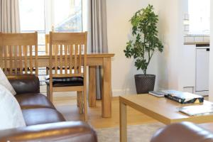 a living room with a wooden table and a couch at Edinburgh Aparthotel in Edinburgh