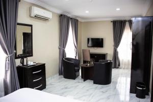 a hotel room with a bed and a desk and a television at Noah's Ark Hotel & Suites in Maroko