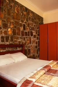 a bedroom with a brick wall and a bed at Xenia house in Kigali +18 photos