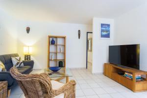 a living room with a couch and a tv at Bel appartement au calme et cosy à deux pas de la plage in Le Gosier +9 photos