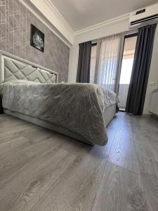 a bedroom with a bed and a wooden floor at Modern Yerevan Apartment-Brand New in Yerevan