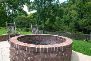 two chairs sitting around a brick fire pit at Riverfront Gem in Townsend