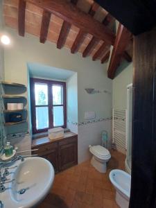 un bagno con lavandino, WC e finestra di Appartamento Dolce Sguardo su Orvieto a Orvieto