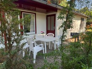 a white table and chairs on the patio of a house at Feriendorf Seddiner See - Bungalow 1 in Seddin