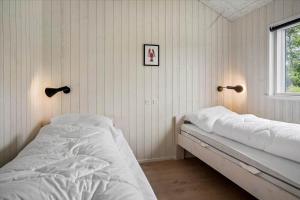 a bedroom with two beds and a window at BV208-Blavand-Strandparken-16 in Blåvand