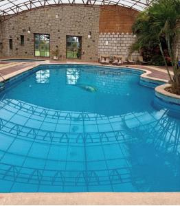 a large swimming pool with blue water at Hotel y centro de convenciones MANSION INN in San Mateo Texcalyacac +14 photos