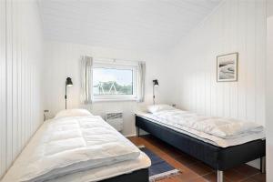 two beds in a white room with a window at BV117-Vejers-Strand-Engesovej-34 in Vejers Strand