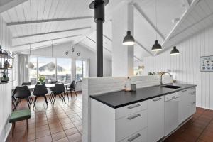 a kitchen with white cabinets and a table and chairs at BV117-Vejers-Strand-Engesovej-34 in Vejers Strand