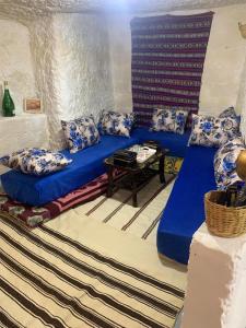 a living room with a blue couch and a table at كهوف يحيى للسياحة والمبيت البهاليل in Bhalil