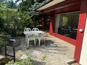 SeddinにあるFeriendorf Seddiner See - Bungalow 7のパティオ(白いテーブル、白い椅子付)