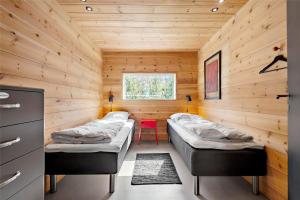 a room with two beds in a wooden cabin at BV186-Blavand-Lyngsletten-41 in Blåvand